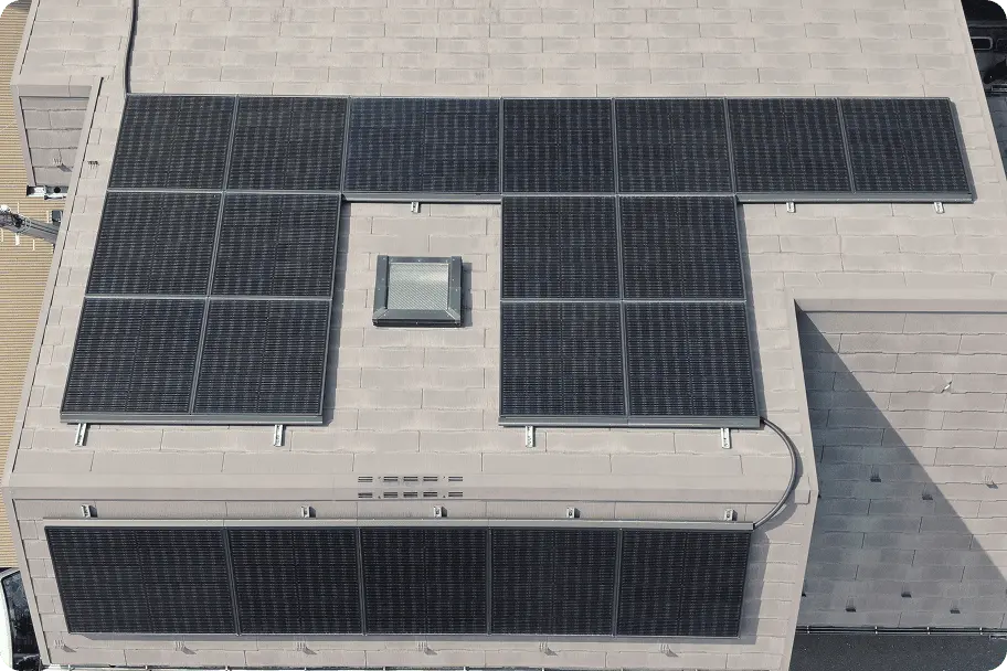 金属製のフラットな屋根に広く設置された太陽光パネルの全体写真